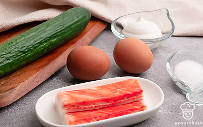 Отварите куриные яйца вкрутую и очистите. Снимите упаковку с крабовых палочек. Помойте огурец.
