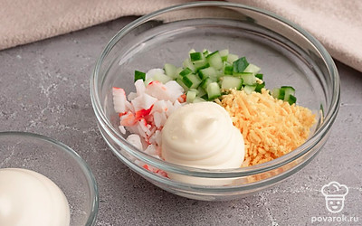 В миску выложите крабовые палочки, огурец, желтки и майонез. Все перемешайте. Попробуйте и посолите по вкусу