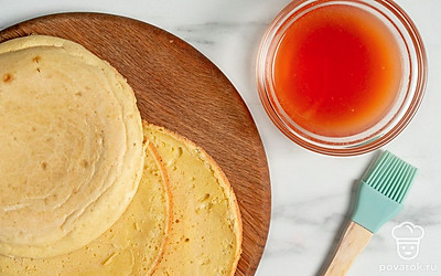 Выжмите сок из апельсинов. Смешайте его с коньяком и вином. Смажьте пропиткой все коржи.