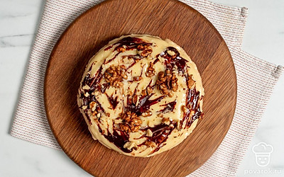 Растопите шоколад и украсьте им торт перед подачей. В завершении выложите на десерт несколько грецких орехов.