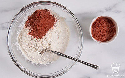 Всыпьте сахар и 2 ст. л. какао-порошка в миску с просеянной мукой, перемешайте ингредиенты.