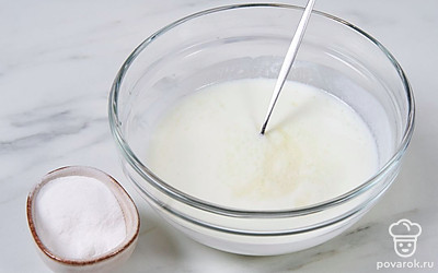 Перелейте кефир комнатной температуры в отдельную миску, добавьте в него соду, перемешайте, чтобы погасить ее кефиром.