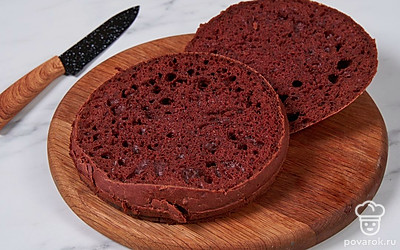 Извлеките остывший бисквит из формы и разрежьте его вдоль на два одинаковых по толщине коржа.