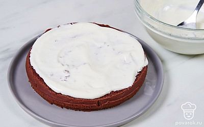 Смажьте бисквитный корж на блюде половиной получившегося сметанного крема.