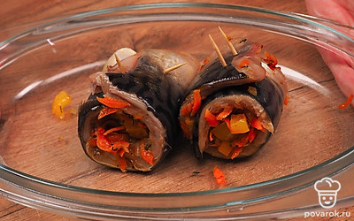 Разделайте скумбрию. Отделите филе, проверьте, чтобы не осталось косточек. Филе посолите и поперчите. Натрите сыр на крупной терке. Посыпьте сыром филе. Равномерно распределите обжаренные овощи по кусочкам рыбы. Каждую половину рыбы скрутите в рулет и закрепите зубочисткой, чтобы рулет не развернулся. Разогрейте духовку до 190 ˚C. Запеките рулеты на противне, покрытом фольгой, в течение 30 минут. Перед подачей уберите из рыбы зубочистки.