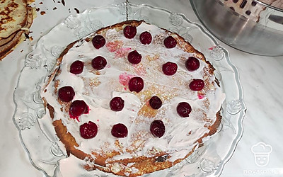 Добавьте ягоды вишни. Соберите торт из всех блинов и крема. Торт отправьте в холодильник на 3 часа пропитаться.