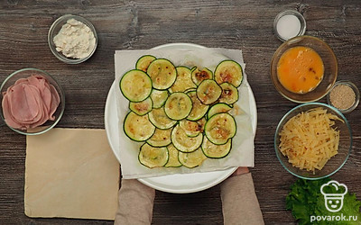 Приготовьте цукини. Налейте в сковороду растительное масло. Поставьте ее на огонь и выложите цукини. Посолите. Обжаривайте по 2-3 минуты с каждой стороны до золотистости. Выложите на бумажное полотенце, чтобы оно впитало лишнее масло.