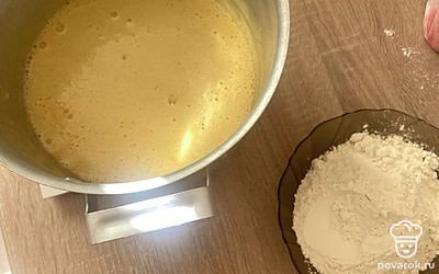 Снимаем с плиты и даем остыть 1 минуту. После просеиваем муку в 2 подхода. Когда мешать станет тяжело, руками продолжаем смешивать на коврике, посыпанном мукой.