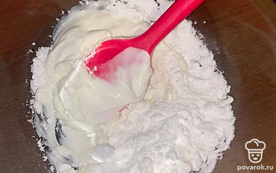 Готовим крем. Сметану и сахарную пудру перемешиваем лопаткой.