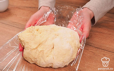 Приготовьте тесто. Выложите в миску сметану и размягченное сливочное масло. Добавьте соль, сахар и взбейте миксером 1-2 минуты. Добавьте яйца и снова взбейте миксером 3-5 минут до однородной массы. Добавьте в миску небольшими порциями просеянную муку, разрыхлитель и хорошо перемешайте. Должно получиться густое тесто. Выложите тесто на поверхность, посыпанную мукой. Месите, пока оно не станет эластичным и гладким. Заверните тесто в пищевую пленку и уберите в холодильник на 30 минут.