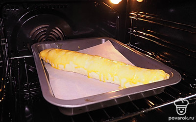 Приготовьте рулет. Достаньте тесто из холодильника и раскатайте до толщины 0,5 см. Распределите начинку по тесту ровным слоем. Сверните тесто в рулет и залепите края. Смажьте рулет с орехами яичным желтком. Положите на противень, застеленный бумагой для выпечки. Поставьте в духовку, разогретую до 180 ˚C. Через 30 минут достаньте и немного остудите ореховый рулет.