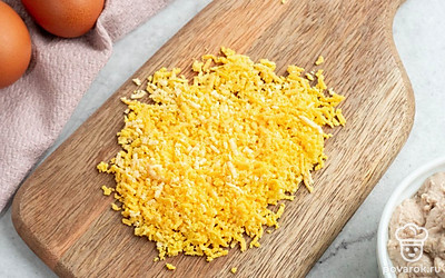 Вареные куриные яйца разрежьте пополам вдоль. Аккуратно отделите желтки от белков. Половинки белков отложите пока в сторону, а вареные яичные желтки разомните вилкой.