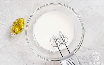 Взбейте миксером куриные яйца с сахаром до пышной массы. Добавьте молоко, растительное масло и тщательно перемешайте. 