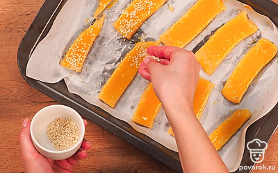 Приготовьте сырные палочки. Смажьте стол или рабочую поверхность, на которой будете раскатывать тесто, растительным маслом. Раскатайте тесто в пласт толщиной 0,5 см и нарежьте на полоски шириной 1-1,5 см.