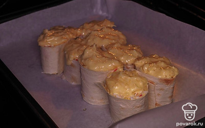 Переходите к последнему этапу. На противень постелите бумагу для выпечки, разложите рулеты, оставляя между ними небольшое пространство. Сверху посыпьте сырной смесью. Поставьте в разогретую до 200 ˚C духовку на 20 минут. Сырная «шапка» на рулетах должна увеличиться в объеме и зарумяниться.