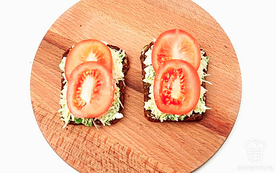 Получившуюся массу выложите на бутерброды. Сверху разместите ломтики помидоров.