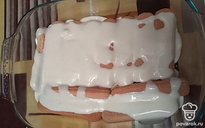 Выкладываем на дно формы слой печенья, сверху заливаем кремом, посыпаем орешками. 