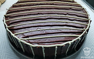 Покрыть весь торт глазурью. Украсить полосками глазури и крема. 