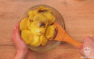 Подготовьте картофель. Очищенные клубни картошки нарежьте на тонкие пластины. Их толщина должна быть не более двух миллиметров. Выложите кусочки картофеля на бумажное полотенце, чтобы оно впитало остатки влаги. Сухие ломтики сложите в миску. Поперчите, посолите и добавьте растительное масло. Аккуратно перемешайте картофельные слайсы, чтобы не сломать их.