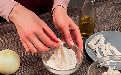 Нарежьте кальмаров. Размороженных и очищенных кальмаров нарежьте колечками толщиной 1 см. Добавьте соль и перец, обваляйте каждое колечко в муке.