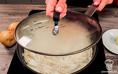 Приготовьте сметанный соус. Лук нарежьте полукольцами. Обжарьте в течение 3 минут на той же сковороде, где были кальмары. Когда лук станет мягче, переложите в сковороду кольца кальмаров и залейте сметаной. Накройте сковороду крышкой, тушите на медленном огне 15 минут. Сметана не даст кальмару стать жестким.