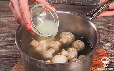 Замаринуйте шампиньоны в банке. В сотейник поместите грибы, налейте воду, добавьте соль, сахар, чеснок, семена укропа, лаврушку и перец. Поставьте емкость на сильный огонь и накройте крышкой. После закипания варите грибы еще 5 минут. Отключите нагрев и влейте лимонный сок. Уберите в прохладное место сотейник примерно на 4 часа.