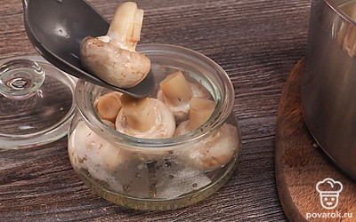 Завершите консервацию. Переложите грибы в стерилизованные банки, залейте маринадом и закройте капроновыми крышками.