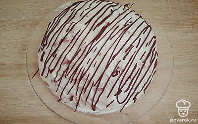Приготовьте шоколадную глазурь. Растопите шоколад на водяной бане, добавьте кусочек сливочного масло и перемешайте. Дайте массе немного остыть, поместите в корнетик и нанесите узор на охлажденный торт.