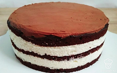 Приготовьте ганаш для покрытия торта. Растопите шоколад на водяной бане и добавьте очень мягкое сливочное масло. Хорошо перемешайте и пробейте блендером. Можно покрывать торт сразу, а можно оставить ганаш на некоторое время и покрывать торт несколько позже – так он приобретет более плотную консистенцию. Нанесите ганаш на поверхность торта и украсьте по своему вкусу и желанию.