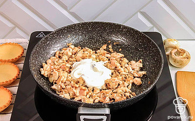 Обжаривайте курицу с грибами в течение 5 минут на среднем огне. Добавьте сметану.