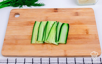 Нарежьте рыбу тонкими ломтиками. Огурец разрежьте на тонкие, широкие дольки. Измельчите зелень: можете использовать укроп, петрушку, кинзу.