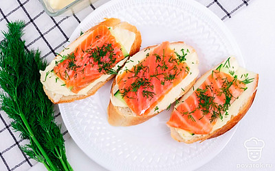 Переложите готовые бутерброды на тарелку для подачи, сверху посыпьте измельченной зеленью.