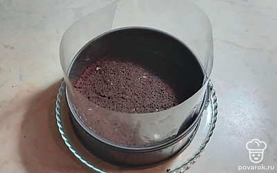 На блюдо поставьте форму для выпечки, вставьте ацетатную пленку, выложите на дно блюда первый корж.