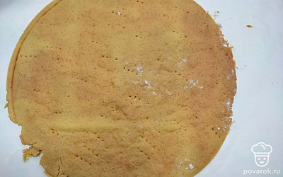 Отдохнувшее тесто равномерно разделите на части и скатайте шарики. Скалкой раскатайте в тонкий круглый пласт, наколите вилкой в нескольких местах, отправьте в разогретую духовку. Выпекайте до появления приятного золотистого цвета, примерно 3 минуты. Горячий корж обрежьте по краям, чтобы он был правильной круглой формы. Те же действия проделайте со всеми остальными шариками.