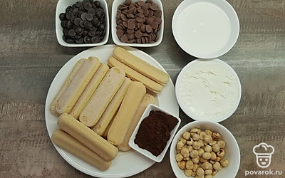 Освободите продукты от упаковки, отмерьте необходимое количество. Сварите кофе любым привычным вам способом, и охладите его до комнатной температуры, затем перелейте в глубокую широкую тарелку. Фундук крупно порубите ножом или при помощи кухонного комбайна. Приготовьте сотейник с толстым дном для растапливания шоколада, миксер и продолговатую форму для кекса, застелив ее пищевой пленкой.