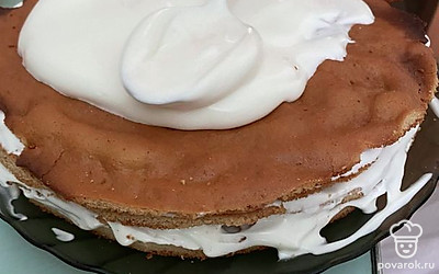 Остывшие медовые коржи обильно перемазываем сметанным кремом.
Также обильно обмазываем кремом верхний корж и бока торта.