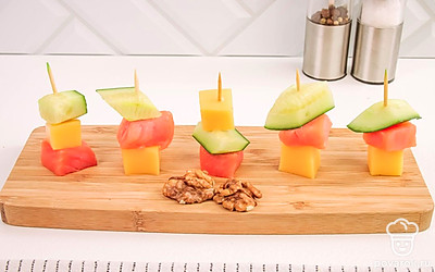 Подавайте эту свежую закуску на одной большой тарелке, чтобы она стала центром притяжения ваших гостей. Украсьте блюдо свежей зеленью, “перьями” из огурца и помидорками черри.