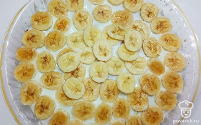 Между слоями выложите нарезанные бананы. Верхний слой смажьте взбитыми сливками. Украсьте и уберите в холодильник на 2 часа.