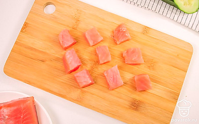 Аккуратно нарежьте семгу на кусочки, соразмерные нарезанному огурцу.