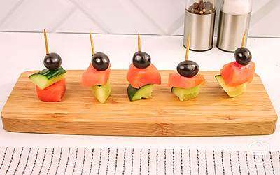 Подавайте канапе на большой плоской тарелке, доске или разделите на несколько порций и обязательно украсьте зеленью или помидорками черри.