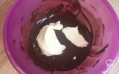 Подготовить ганаш для выравнивания торта. В растопленный тёмный шоколад добавить 100 г сливочного масла, перемешать.