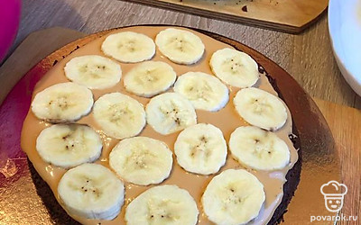 На корж намазать крем, выложить бананы. Повторить со всеми коржами, верхний корж пустой. Торт убрать в холодильник на 1 час.