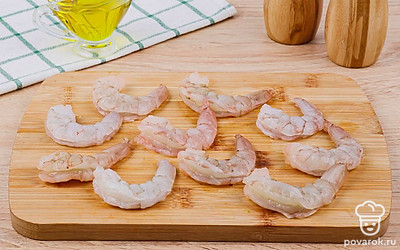 Очистите чеснок и нарежьте тонкими кружочками. Очистите сваренные креветки.