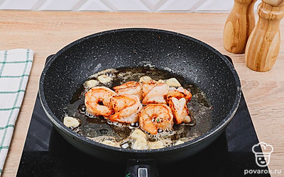 Добавьте к креветкам порезанный чеснок, соль и перец по вкусу. Обжаривайте до золотистой корочки еще 5-8мин.