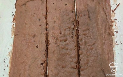 Как только корж испекся, обрезаем края. Режем корж на полосы. 