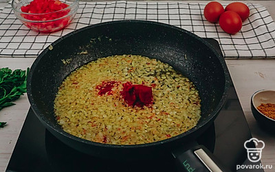 К луку добавьте томатную пасту. Перемешайте.