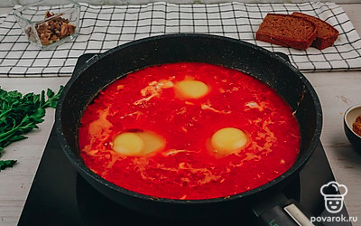 Влейте на сковороду стакан теплой воды – 200 мл. Тушите овощи еще 3-4 минуты. После сделайте лопаточкой углубления и разбейте в них яйца.