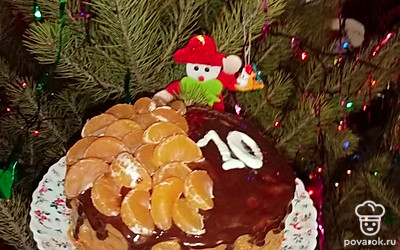 На водяной бане растопите шоколад и покройте сверху торт. Украсьте мандаринами.