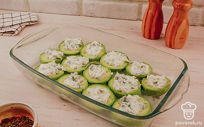 Выложите на цукини слой из майонеза, смешанного с зеленью и чесноком.
