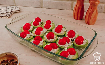 Выложите на майонез порезанные помидорки черри.